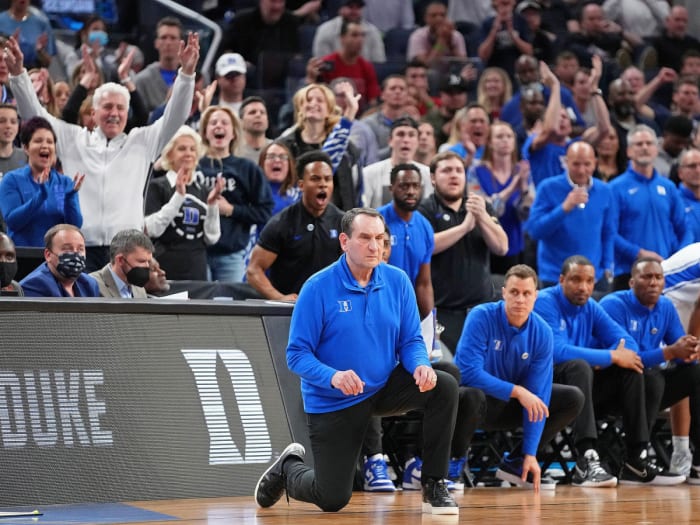 Coach K kneels while coaching